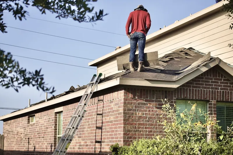 Professional roofer working on a residential roof in Cleves